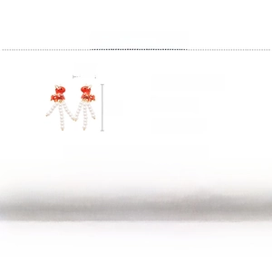 Detailed view of red pony earrings with long faux pearl tassels and silver needles