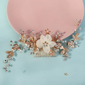 Detail of bridal hair comb featuring white fabric flowers and sparkling crystals