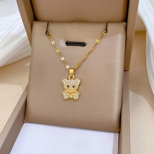 Close-up of a gold teddy bear pendant with full zircon inlay and black stone eyes