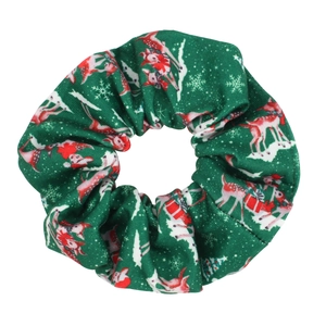 Close-up of green Christmas scrunchie with reindeer, snowflake, and tree festive patterns