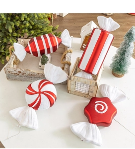 Close-up of red and white striped Christmas candy ornaments on a white festive tabletop