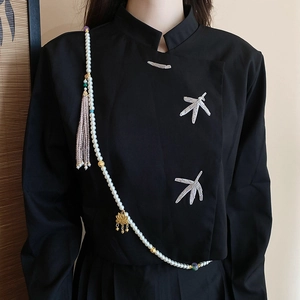 Detail of multi-layer pearl body chain with golden lotus pendant and pink tassel