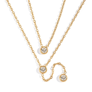 Detail of a gold double-layer Y-shaped necklace featuring three bezel-set cubic zirconia drops