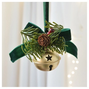 Detailed shot of golden star bell with dark green velvet bow and pine cone ornament