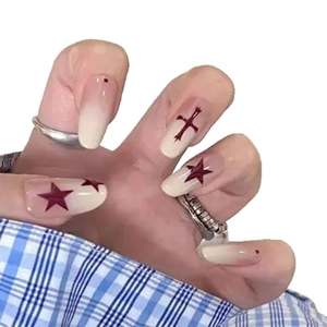Press-on nails with pink gradient, black cross, and red star in long almond shape