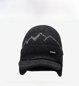 Detail of dark grey knit winter trapper hat with peak pattern and ear protection