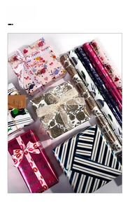 Detailed view of varied holiday gift wrapping papers with elegant floral and stripe patterns