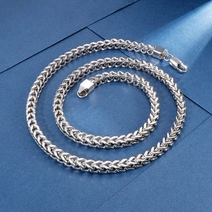 Top-down view of a silver stainless steel dragon bone chain on blue background