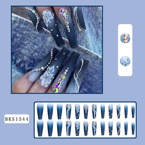 Detailed view of blue gradient press-on nails with 3D white flowers and rhinestones