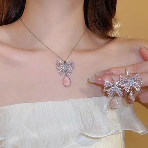 Detail view of pink bow and teardrop crystal pendant necklace and earrings set