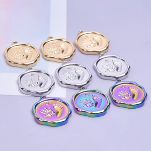 Flat lay of colorful stainless steel pendants with handprint and footprint sun designs
