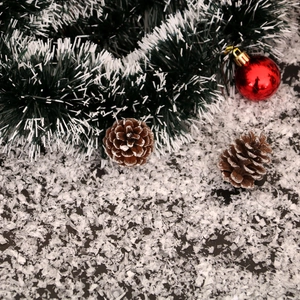 Detailed close-up of Christmas wreath with pine cones and artificial snow powder