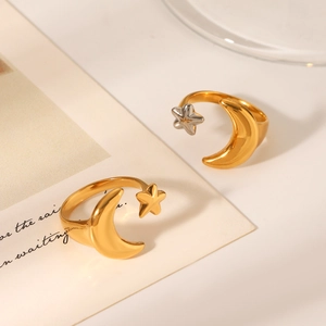 Detail of star and moon open rings in gold and silver finish on a stylish background