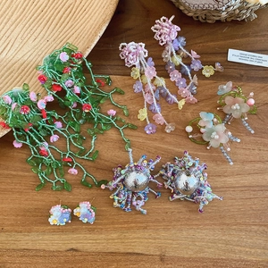 Detalle de varios pendientes de cuentas de flores de cristal de colores estilo Mori