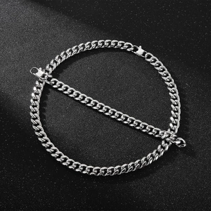 Detail of silver cuban link chain necklace on textured black background