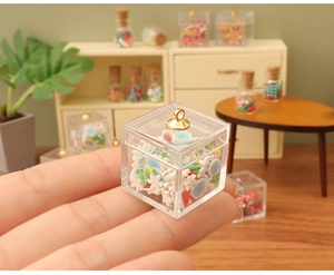 Close-up of a miniature Christmas candy box with golden bell and tiny holiday ornaments