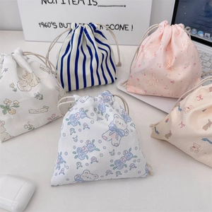 Detailed close-up of cute cartoon drawstring pouches with floral and animal patterns