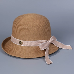 Detail of camel knitted sun hat featuring a ribbon bow and vintage gold rose metal buckle