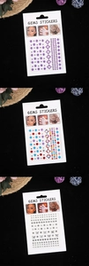 Detail view of colorful multi-shape face and nail gem stickers for stage makeup use