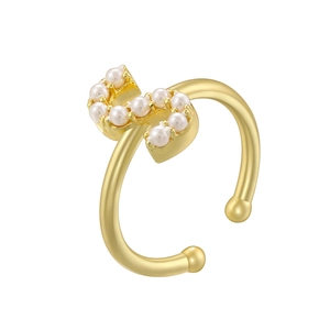Close-up of elegant gold plated open ring featuring small pearls on a curved metal band