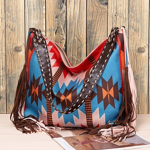 Close-up of bohemian woven tote bag with geometric patterns and long decorative tassels