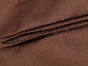 Gros plan sur la texture en satin marron avec coutures fines et détail de poche