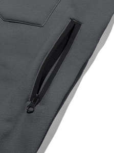 Detail of hidden zipper pocket on dark gray fleece tracksuit with woven texture