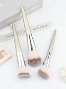 Detailed macro view of champagne gold makeup brushes with fluffy soft gradient bristles