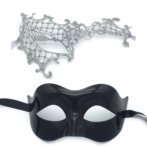 Detail view of lace and glossy masquerade masks with satin ribbon ties on white background