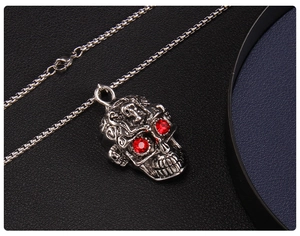 Vue macro d'un pendentif crâne argenté avec yeux en pierres rouges sur cuir noir