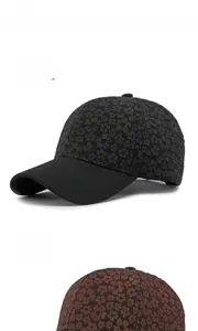 Detail of floral texture on black and coffee baseball caps with adjustable straps