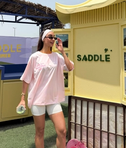 Detailed view of pink oversized t-shirt with script print and drop shoulder sleeves