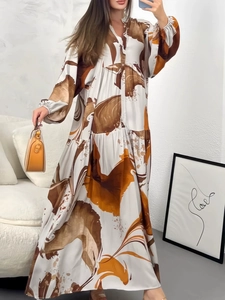 Detail of the elegant V-neckline and abstract print on this long sleeve flowy dress