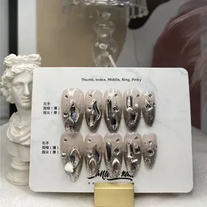 Détail de faux ongles dégradés argentés avec strass de luxe et paillettes fines