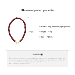 Detailed specs of tiger-eye stone necklace with alloy clasp and rhinestone details