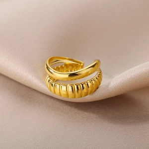Macro shot of double-layered 18k gold open ring featuring smooth and braided croissant texture