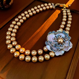 Detail of champagne pearl double necklace with enamel floral pendant and crystals