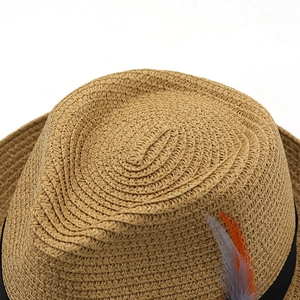Classic straw western cowboy sun hat with black band and feather accent for beach vacation
