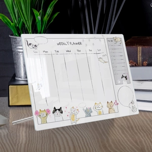 Macro detail of acrylic weekly planner with cute cat icons on a wooden desktop
