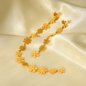 Detail of 18K gold stainless steel daisy long earrings on elegant silk background