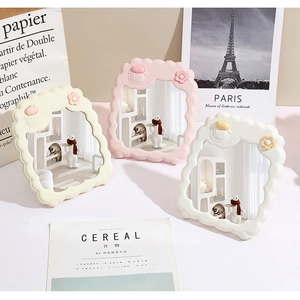 Three sheep-shaped desktop makeup mirrors in cream, pink, and white displayed at home