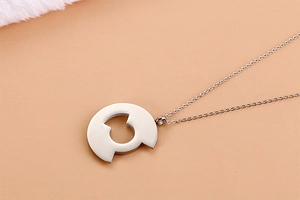 Macro shot of silver titanium steel circular hollow pendant with fine metal chain
