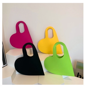 Detailed view of heart-shaped felt handbags in pink, yellow, black and green colors