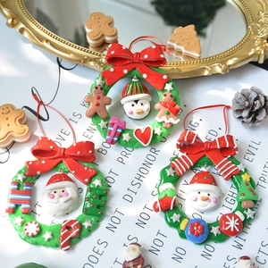 Three assorted polymer clay Christmas wreaths with Santa, snowman and penguin miniatures