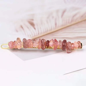 Close-up of golden hair clip with pink and orange natural crystal stones