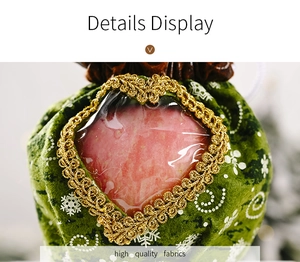 Detail of Christmas green velvet gift bag with heart-shaped window and gold lace trim
