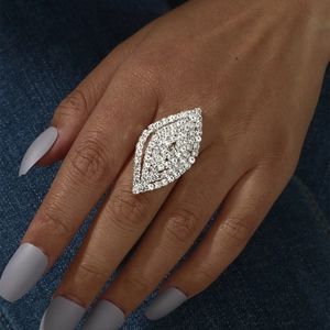 Macro shot of a sparkling marquise hollow ring with white crystals on a denim background