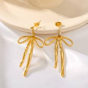 18k gold plated stainless steel bow earrings with sparkling zircon on silk background