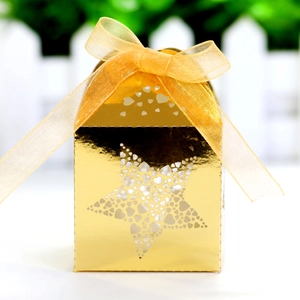 Detailed laser-cut heart pattern on gold star-shaped gift box with organza ribbon