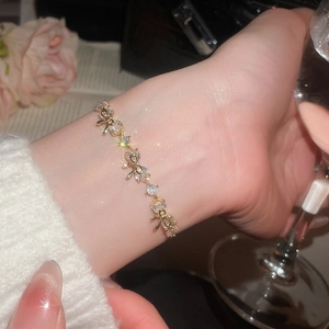 Detailed view of a gold-plated flower bracelet with sparkling zircons on a wrist